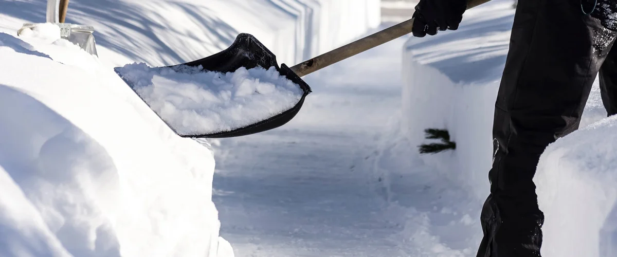 winterdienst-ulm Ein Mann schaufelt den Weg vom Schnee frei für den Winterdienst in Ulm und Umgebung.